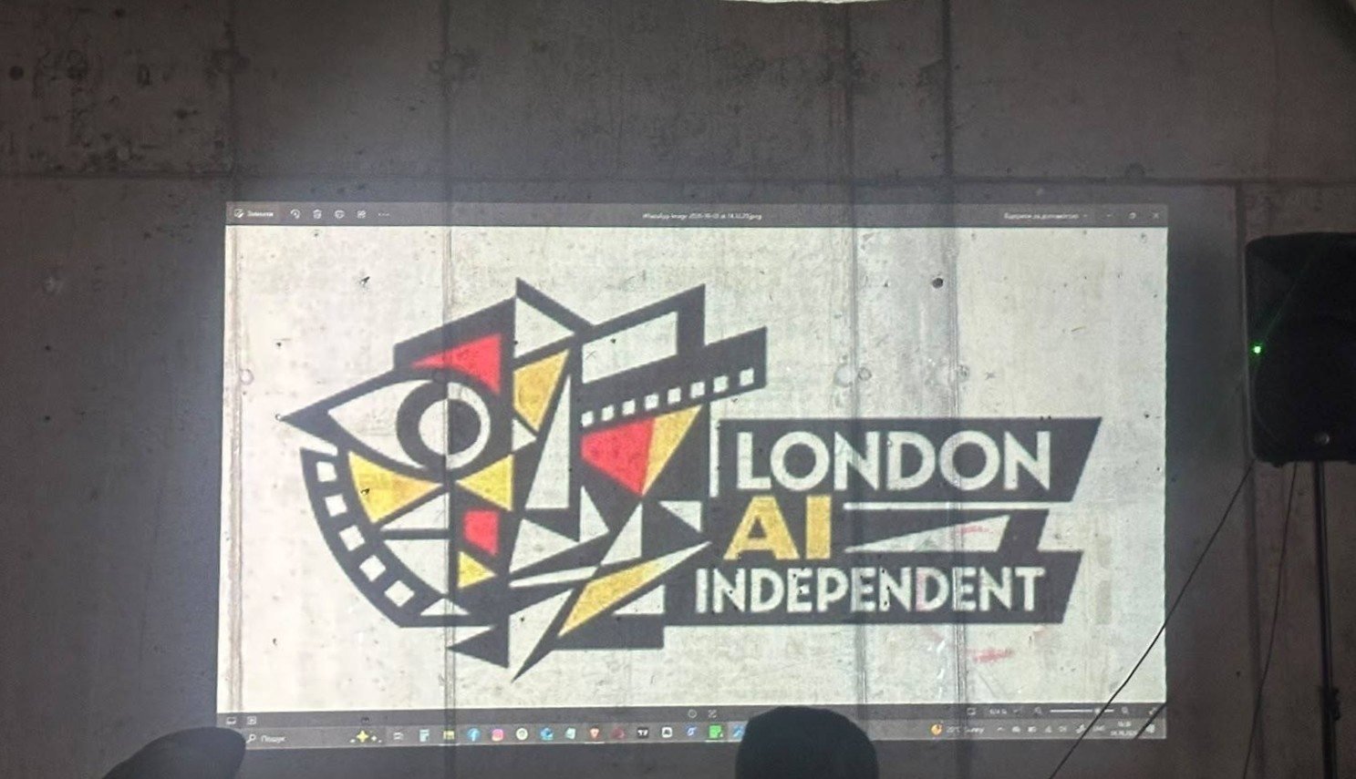 The London AI Independent logo projected onto a bare concrete wall at the Season 1 screening.